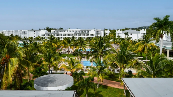 Tropical resort with palm trees and swimming pools.